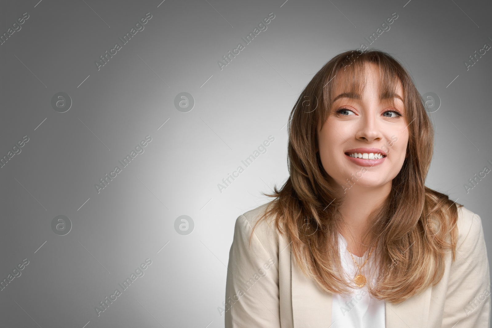 Photo of Attractive woman with stylish haircut on grey gradient background, space for text