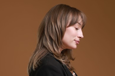 Photo of Attractive woman with stylish haircut on brown background