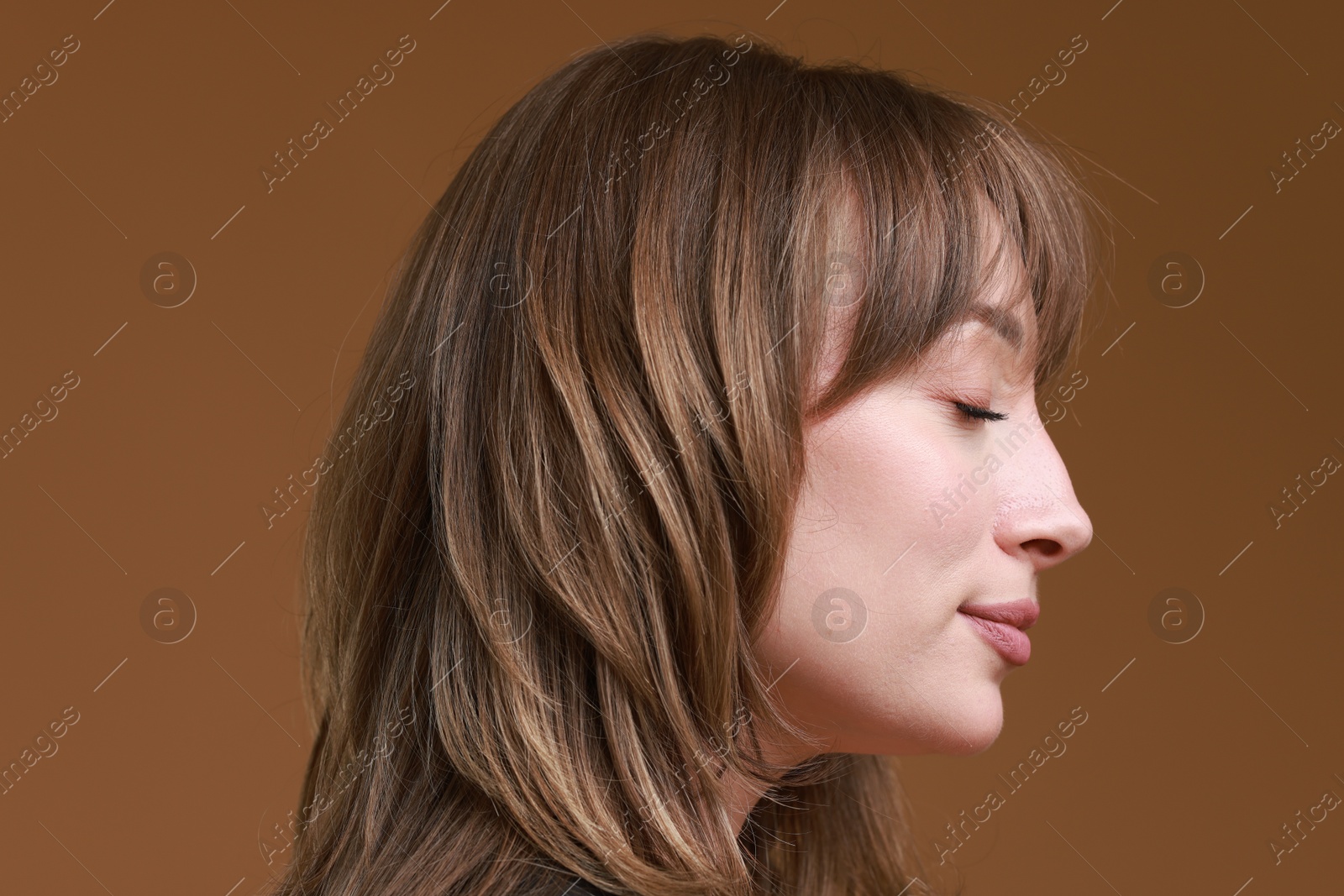 Photo of Attractive woman with stylish haircut on brown background