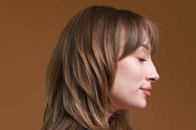 Attractive woman with stylish haircut on brown background