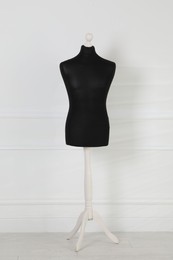 Photo of One black female mannequin near light wall