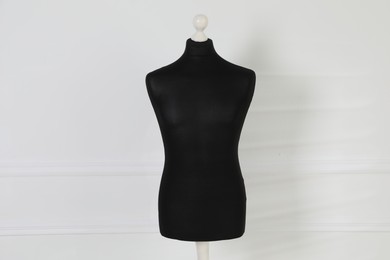 Photo of One black female mannequin near light wall