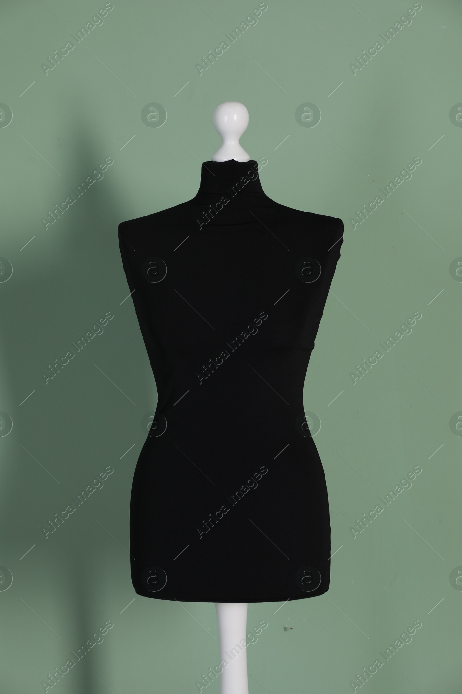 Photo of One black female mannequin near green wall