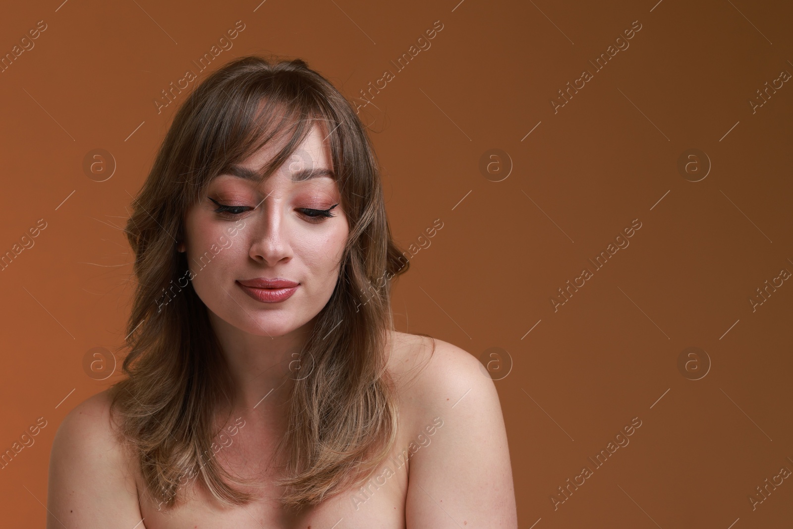 Photo of Attractive woman with stylish haircut on brown background, space for text