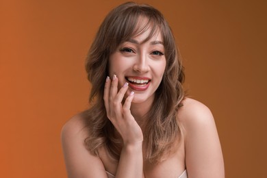 Photo of Attractive woman with stylish haircut on brown background