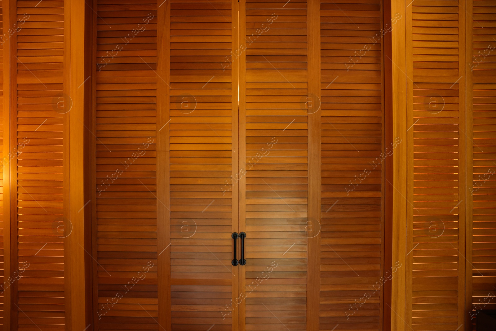 Photo of Stylish wooden sliding doors in hotel room