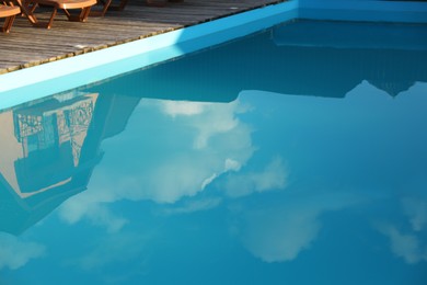 Photo of Outdoor swimming pool with clear water reflecting house and sky