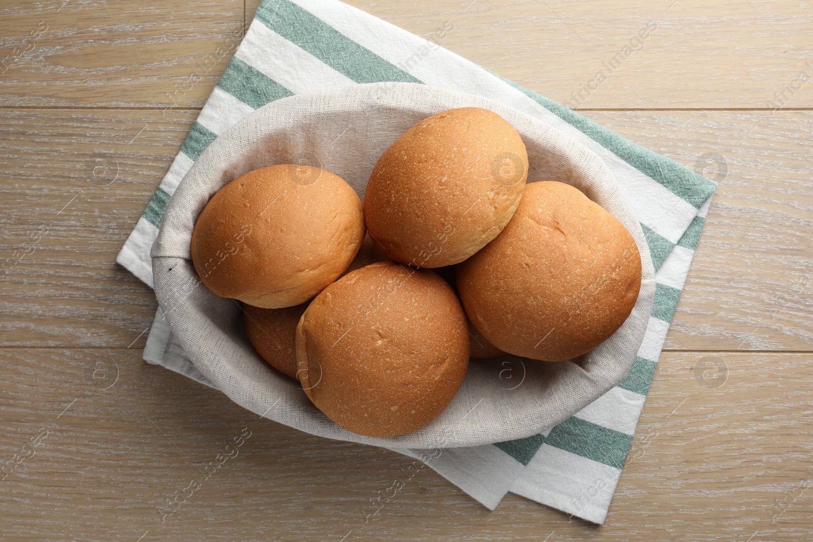 Photo of Fresh tasty buns on wooden table, top view