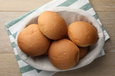 Fresh tasty buns on wooden table, top view