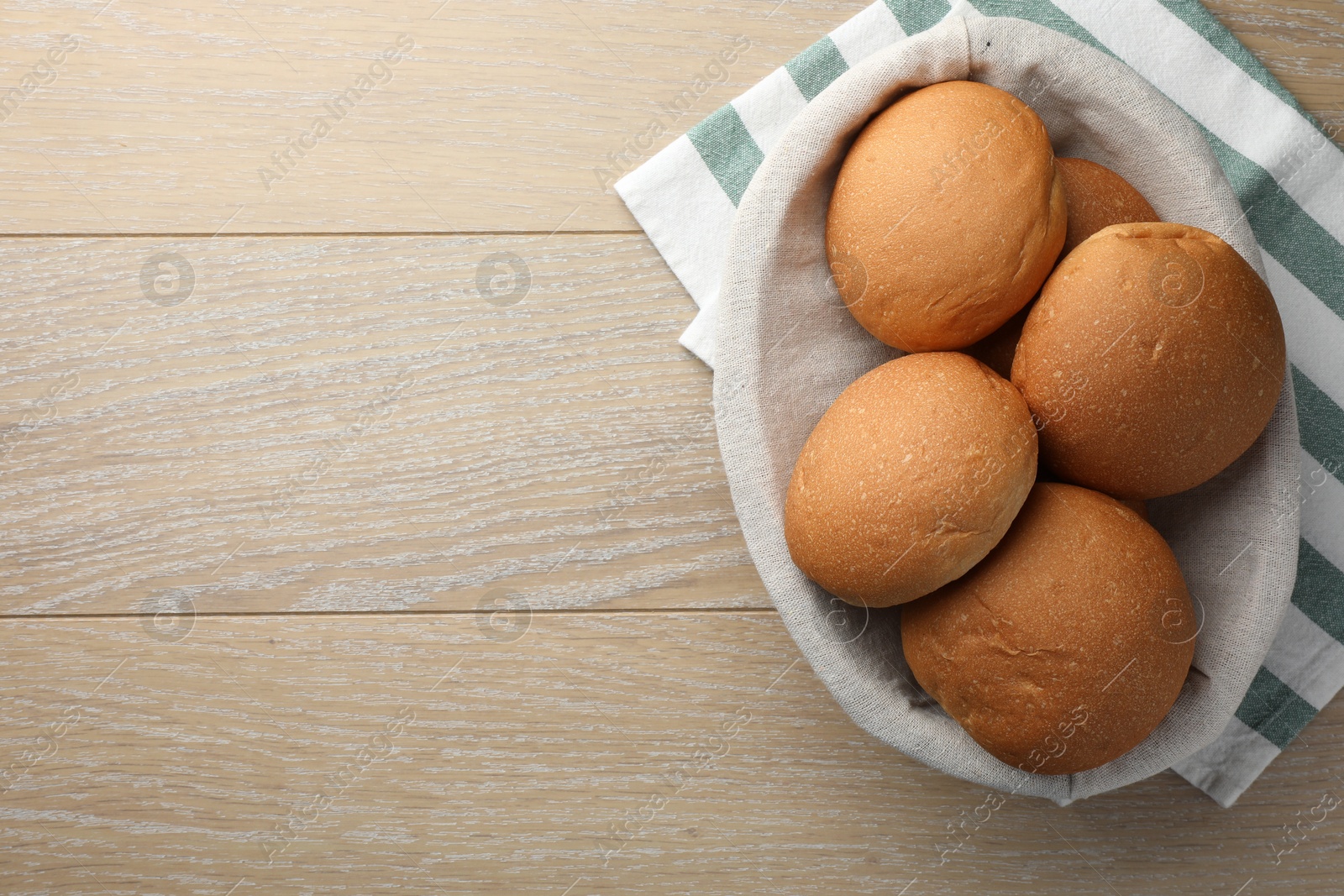 Photo of Fresh tasty buns on wooden table, top view. Space for text