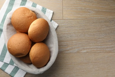 Fresh tasty buns on wooden table, top view. Space for text