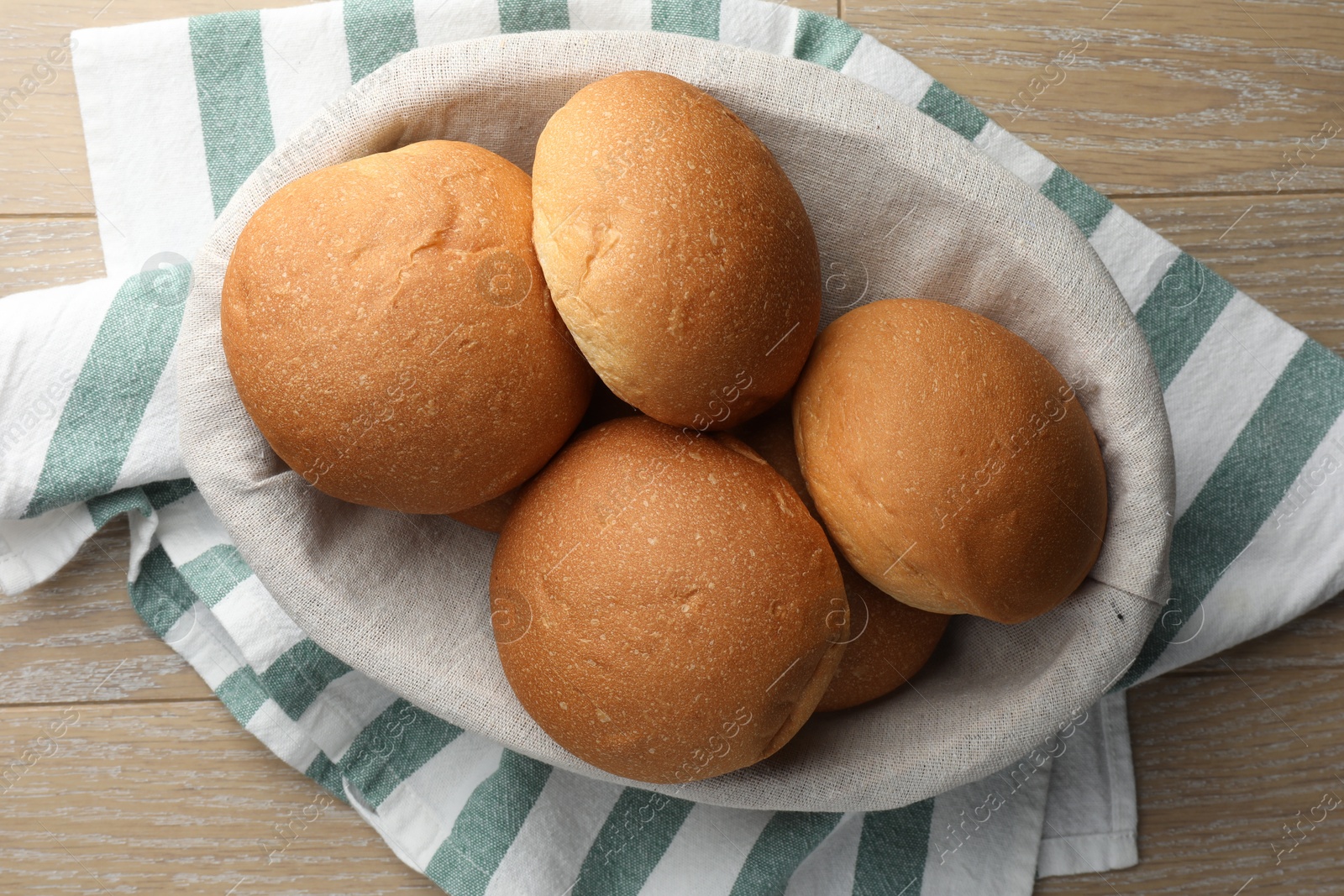 Photo of Fresh tasty buns on wooden table, top view