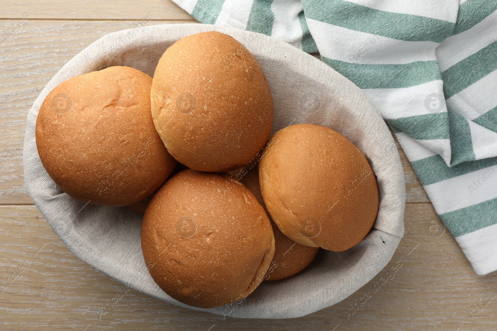 Photo of Fresh tasty buns on wooden table, top view