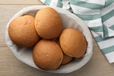 Fresh tasty buns on wooden table, top view