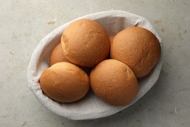 Photo of Fresh tasty buns on grey table, top view