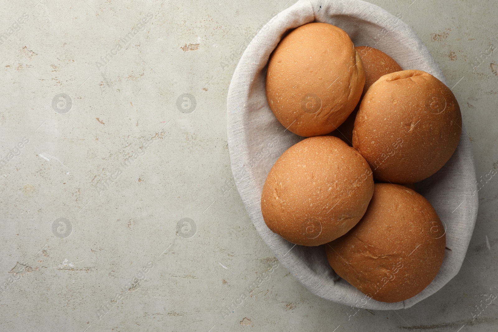 Photo of Fresh tasty buns on grey table, top view. Space for text