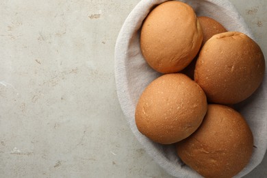 Photo of Fresh tasty buns on grey table, top view. Space for text