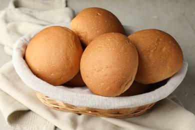 Photo of Fresh tasty buns in basket on table, closeup