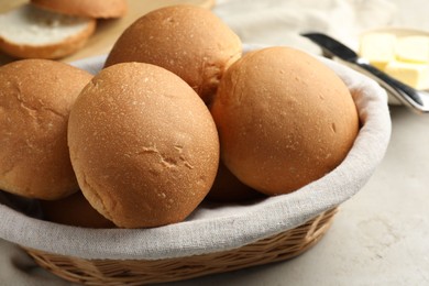 Fresh tasty buns in basket on grey table, closeup