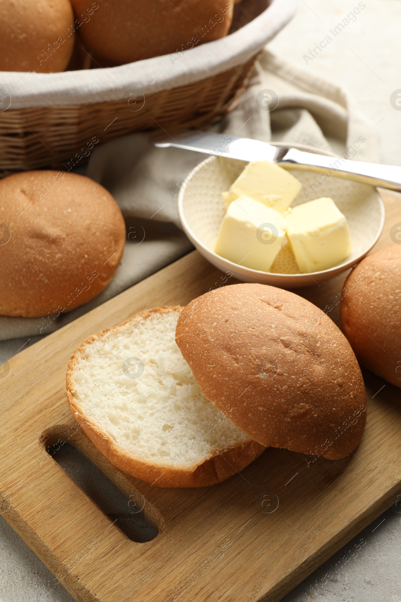 Photo of Fresh tasty buns and butter on table, closeup