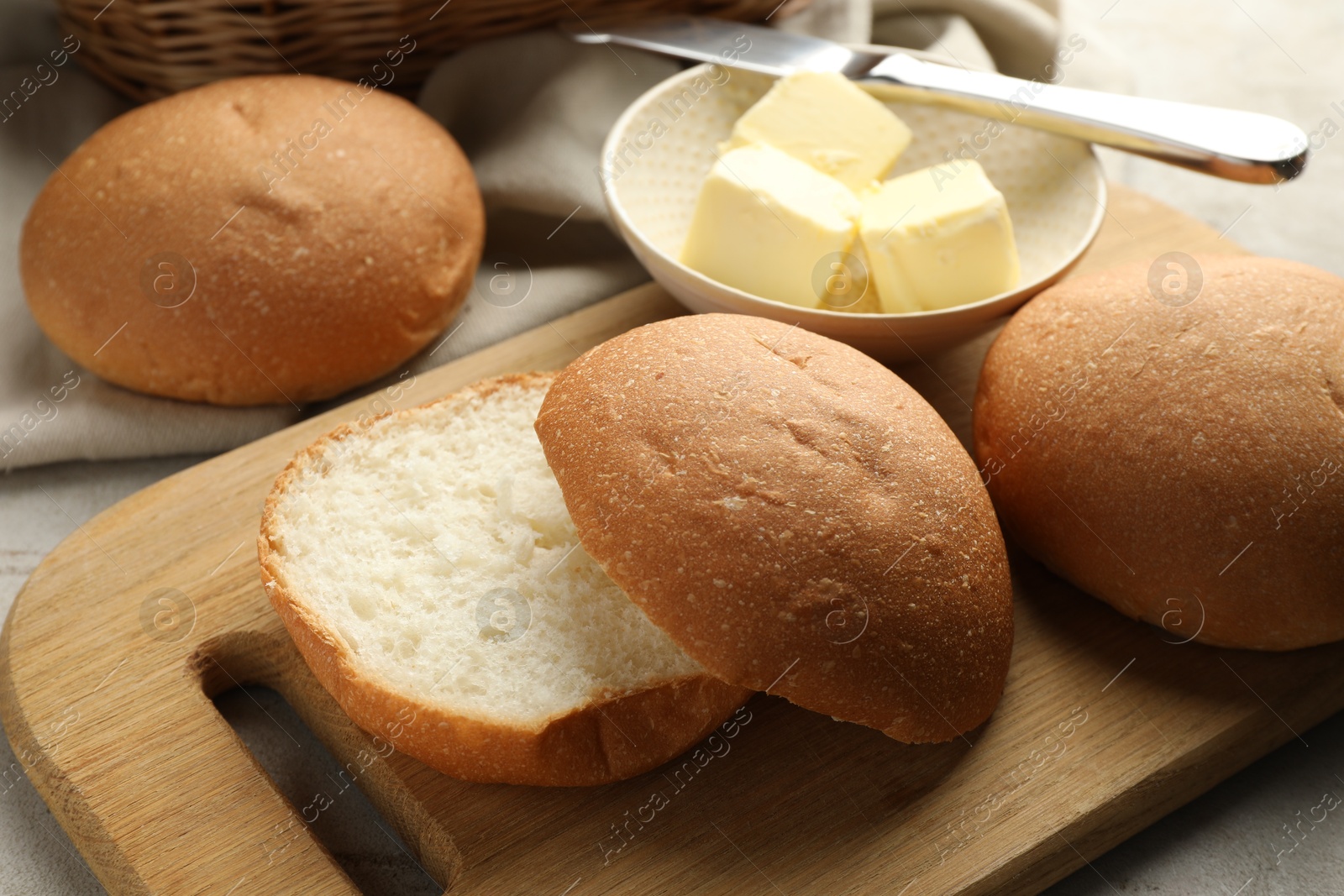 Photo of Fresh tasty buns and butter on table, closeup