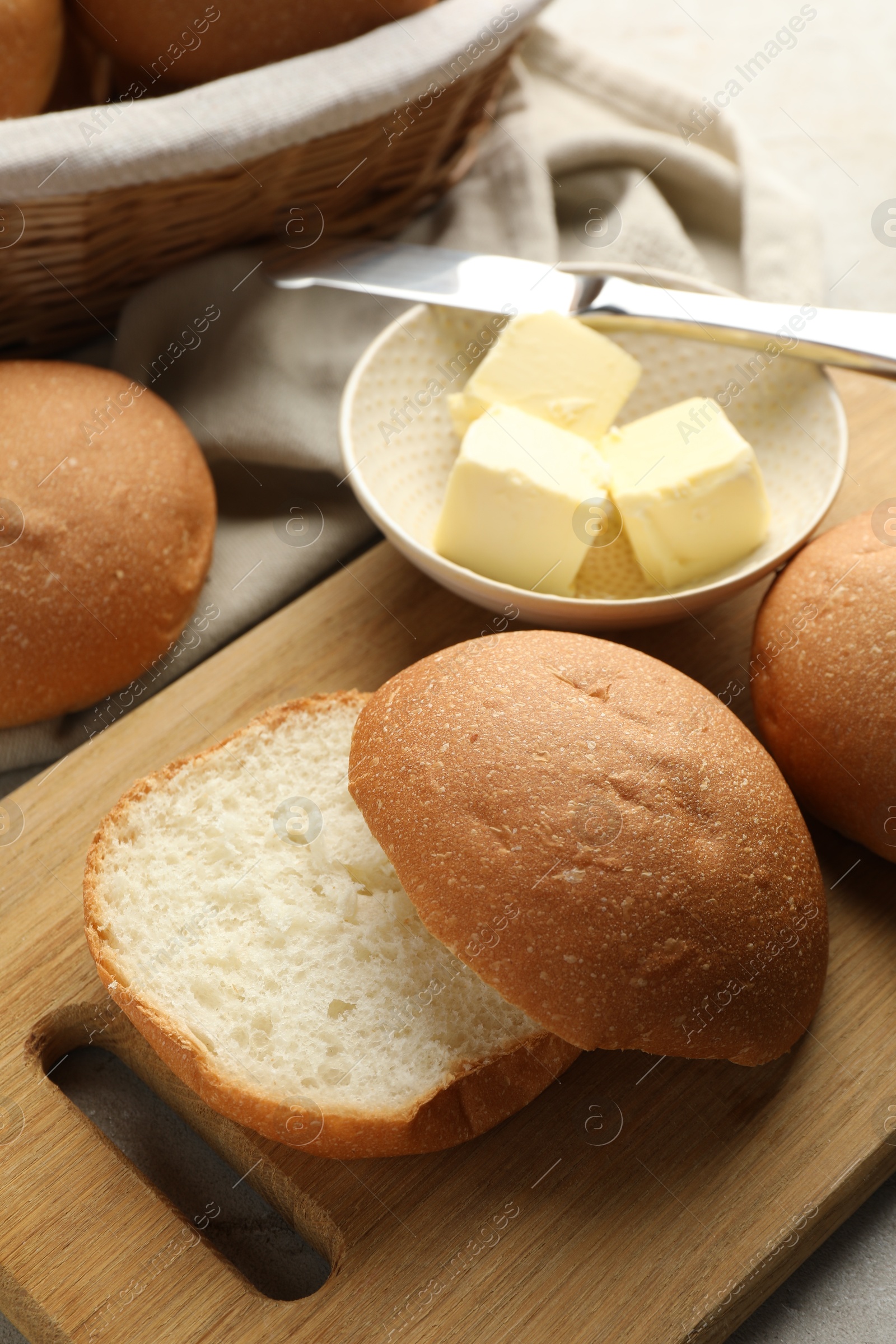 Photo of Fresh tasty buns and butter on table, closeup