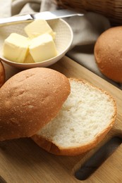 Photo of Fresh tasty buns and butter on table, closeup