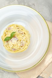 Photo of Plate with delicious pasta Carbonara on grey table, top view