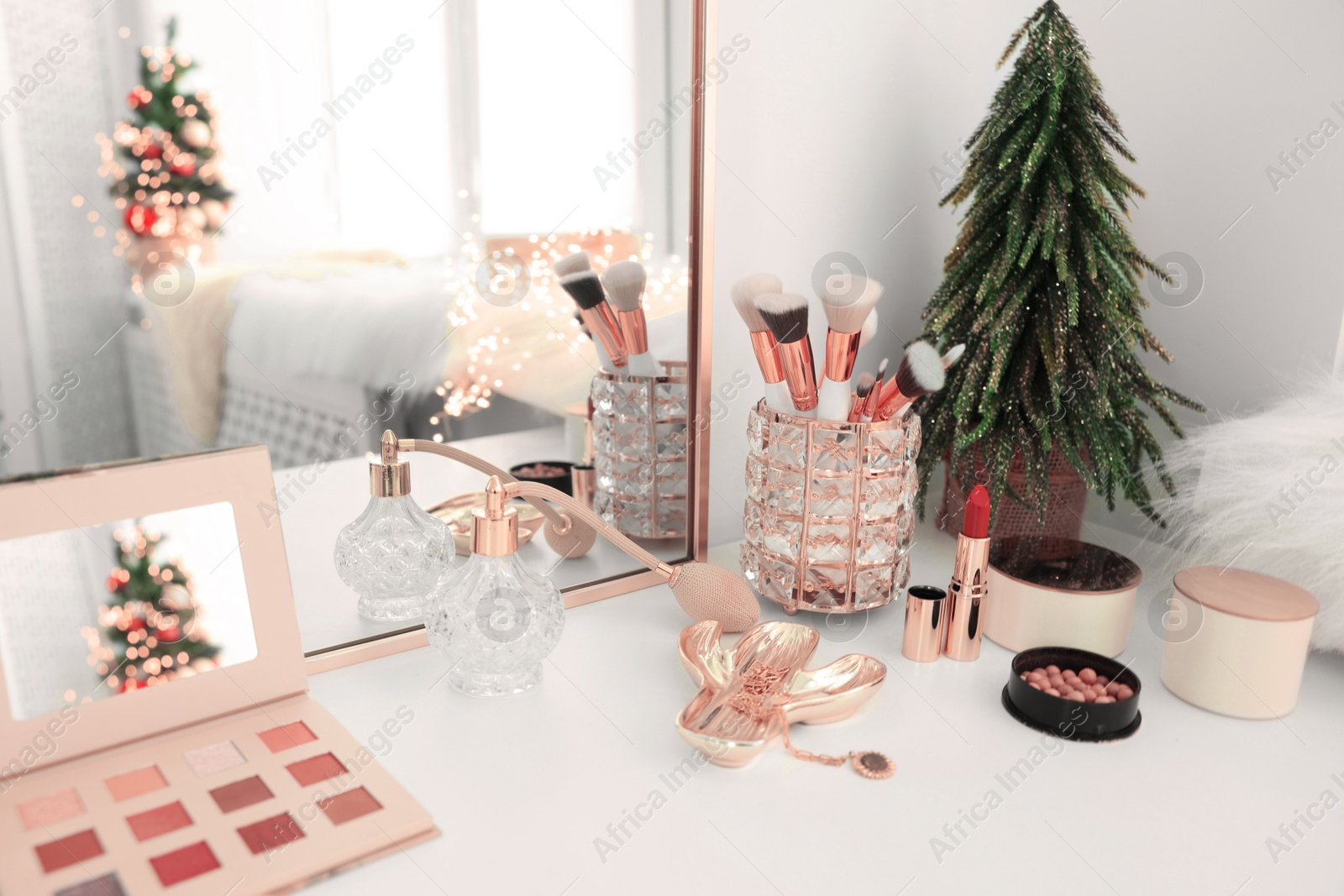 Photo of Makeup brushes and perfume on white table indoors