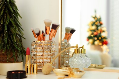 Photo of Makeup brushes and perfume on white table indoors