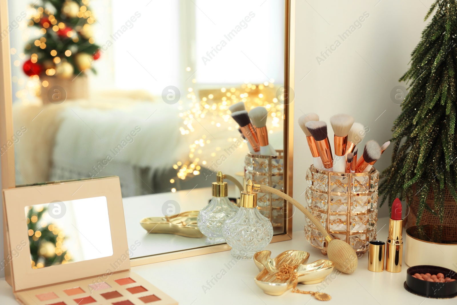 Photo of Makeup brushes and perfume on white table indoors