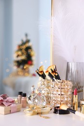 Photo of Makeup brushes, cosmetics and perfume on white table indoors