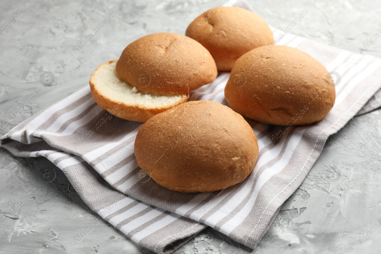 Photo of Fresh tasty buns on grey table, closeup