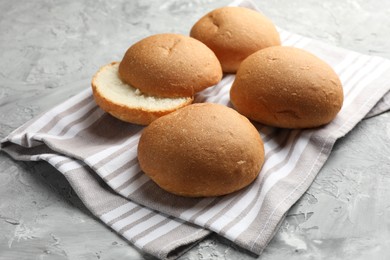 Photo of Fresh tasty buns on grey table, closeup