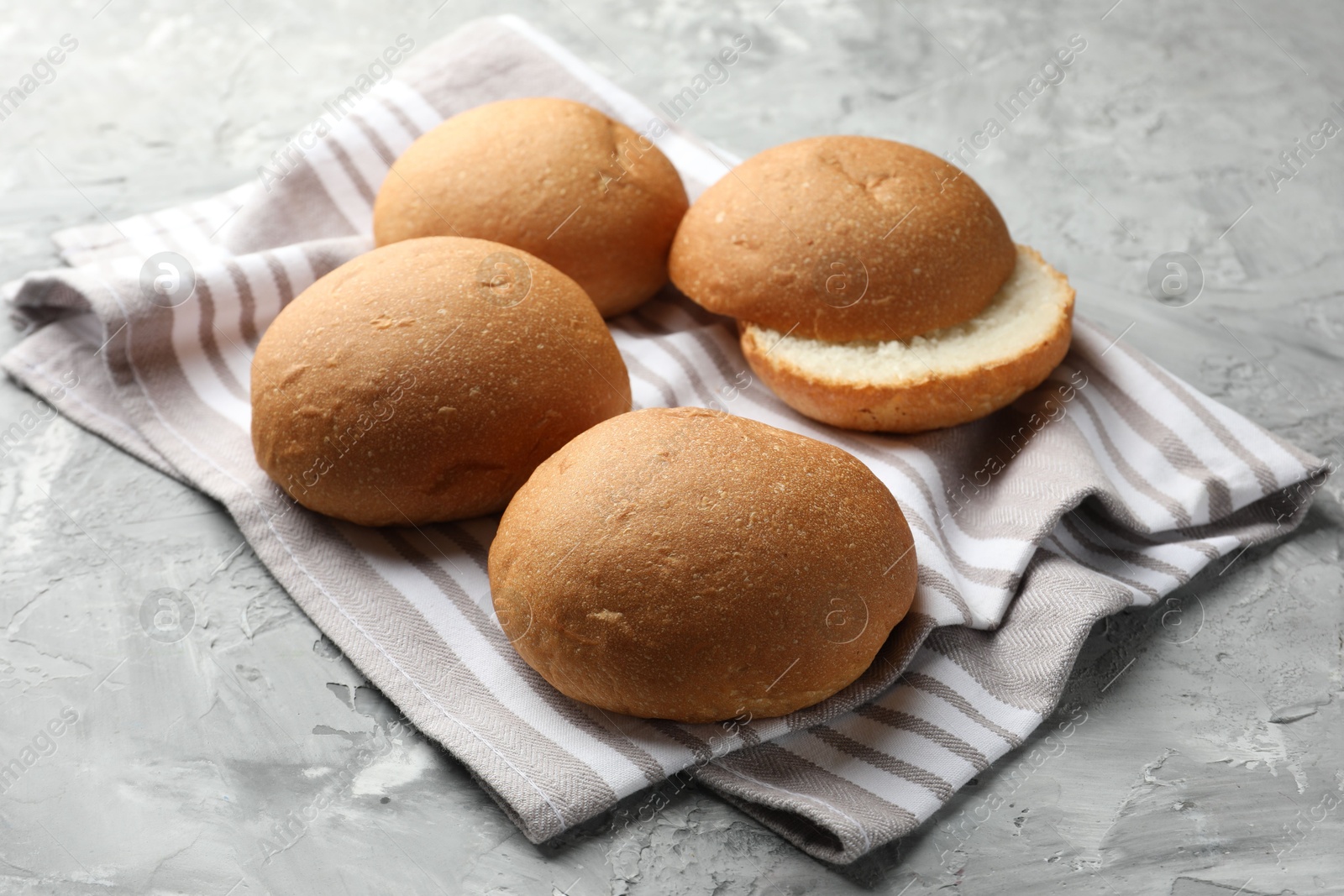 Photo of Fresh tasty buns on grey table, closeup