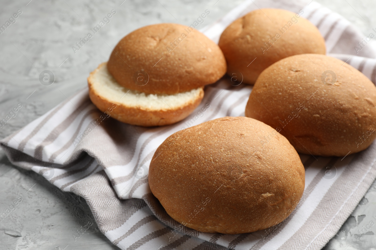 Photo of Fresh tasty buns on grey table, closeup