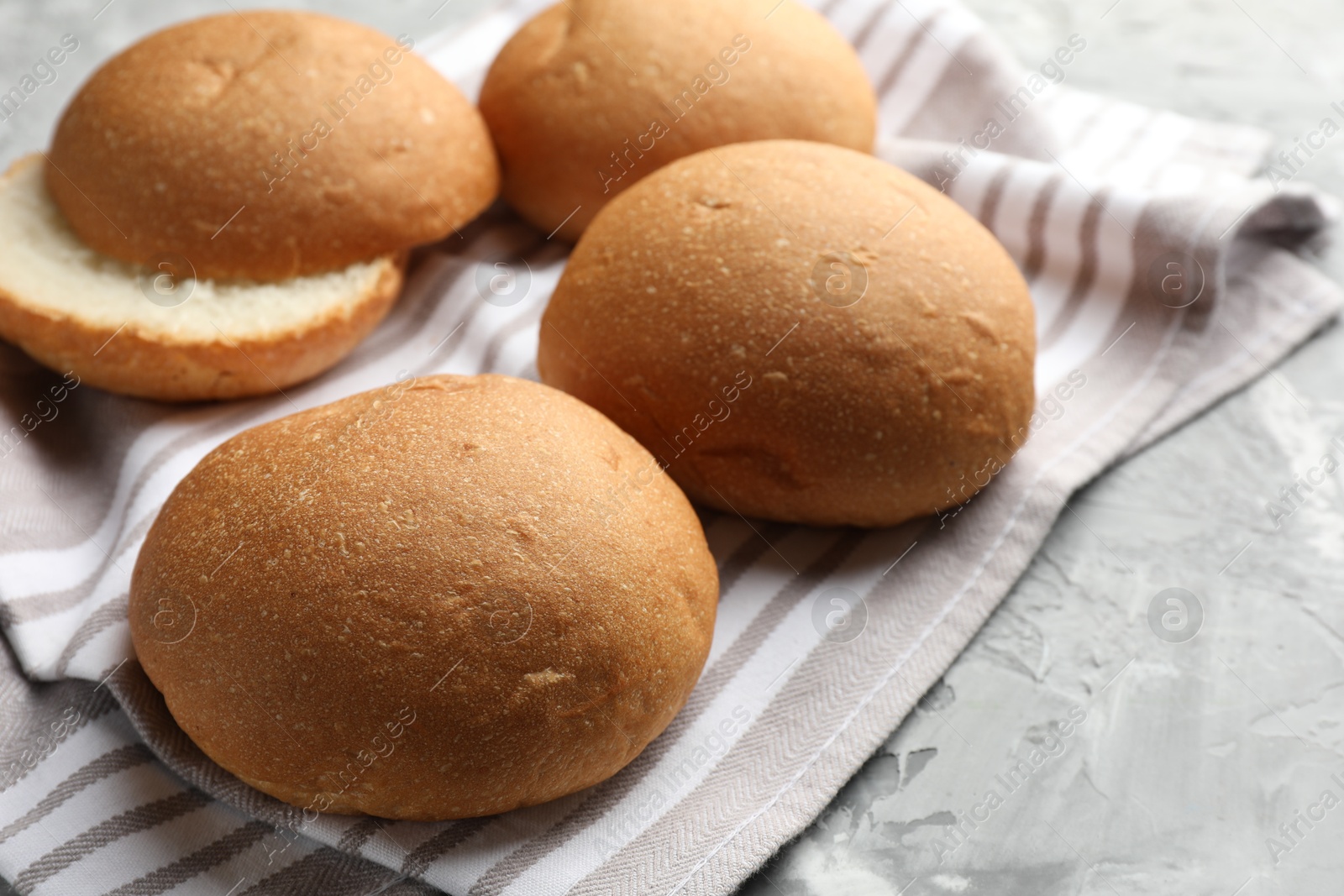 Photo of Fresh tasty buns on grey table, closeup