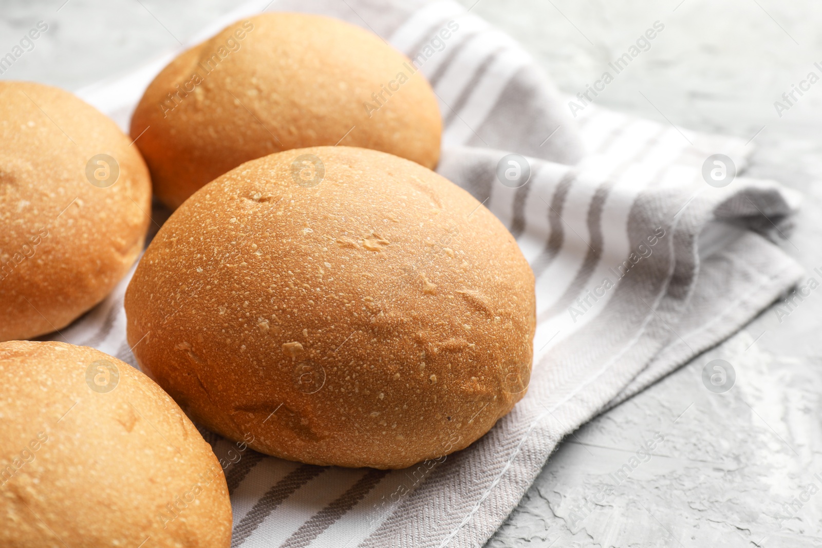 Photo of Fresh tasty buns on grey table, closeup