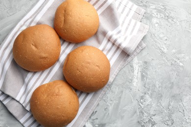 Photo of Fresh tasty buns on grey table, top view. Space for text