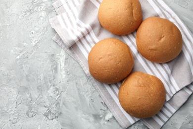 Photo of Fresh tasty buns on grey table, top view. Space for text