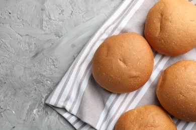 Photo of Fresh tasty buns on grey table, top view