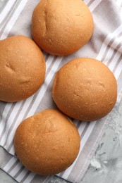 Photo of Fresh tasty buns on grey table, top view