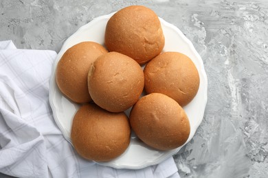 Photo of Fresh tasty buns on grey table, top view