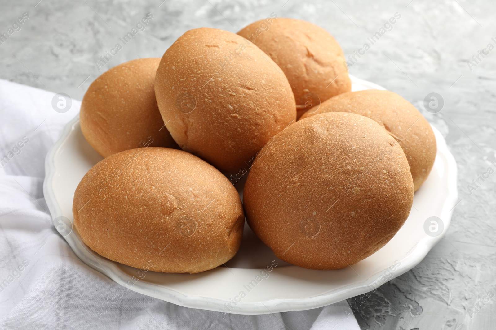 Photo of Fresh tasty buns on grey table, closeup