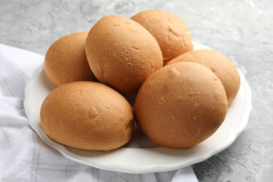 Fresh tasty buns on grey table, closeup