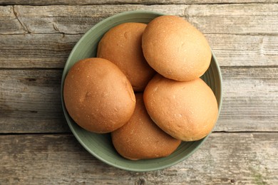 Fresh tasty buns on wooden table, top view