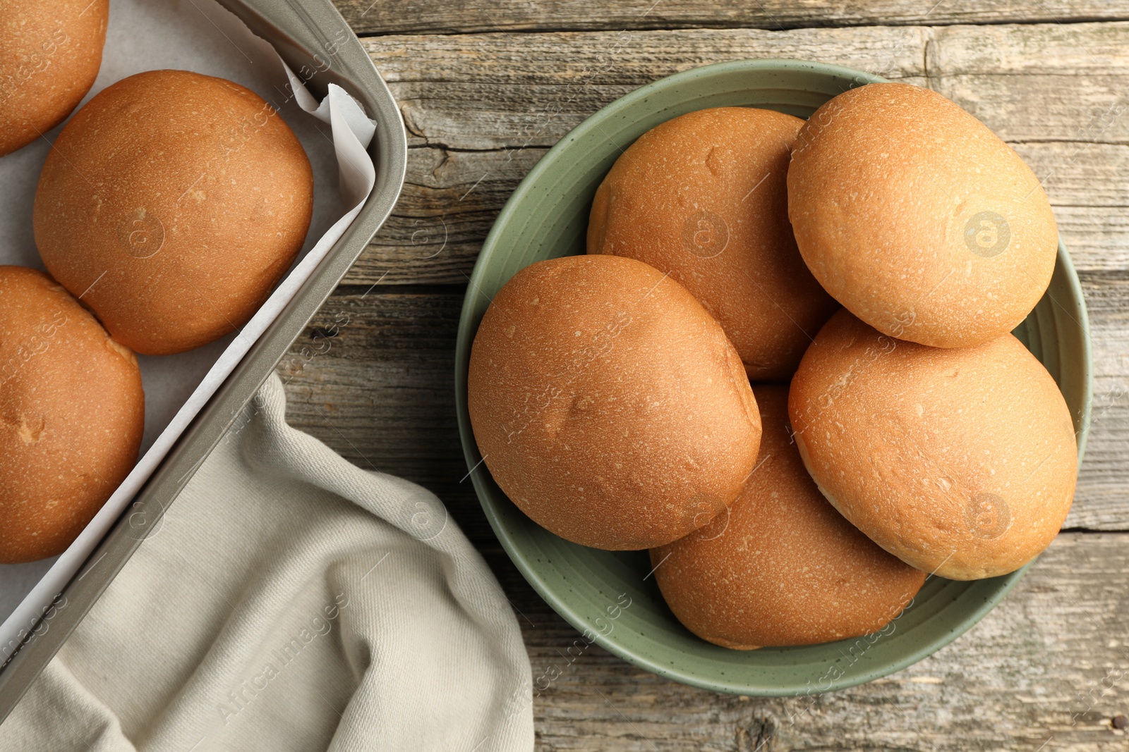 Photo of Fresh tasty buns on wooden table, top view