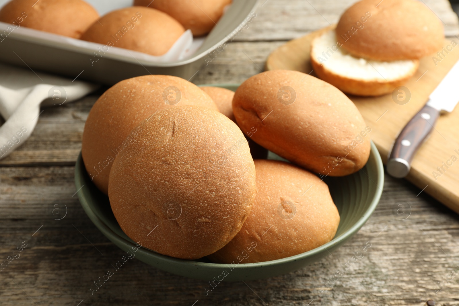 Photo of Fresh tasty buns on wooden table, closeup