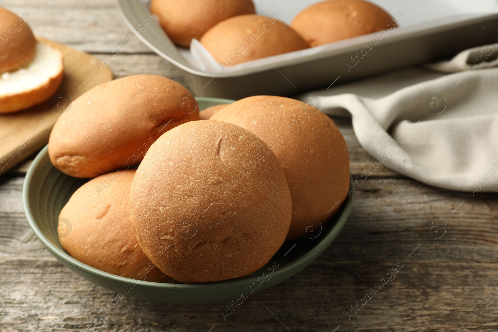 Photo of Fresh tasty buns on wooden table, closeup