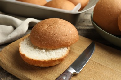 Photo of Fresh tasty buns and knife on table, closeup